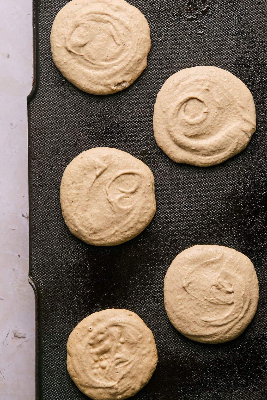 banana oatmeal pancakes cooking on a griddle.
