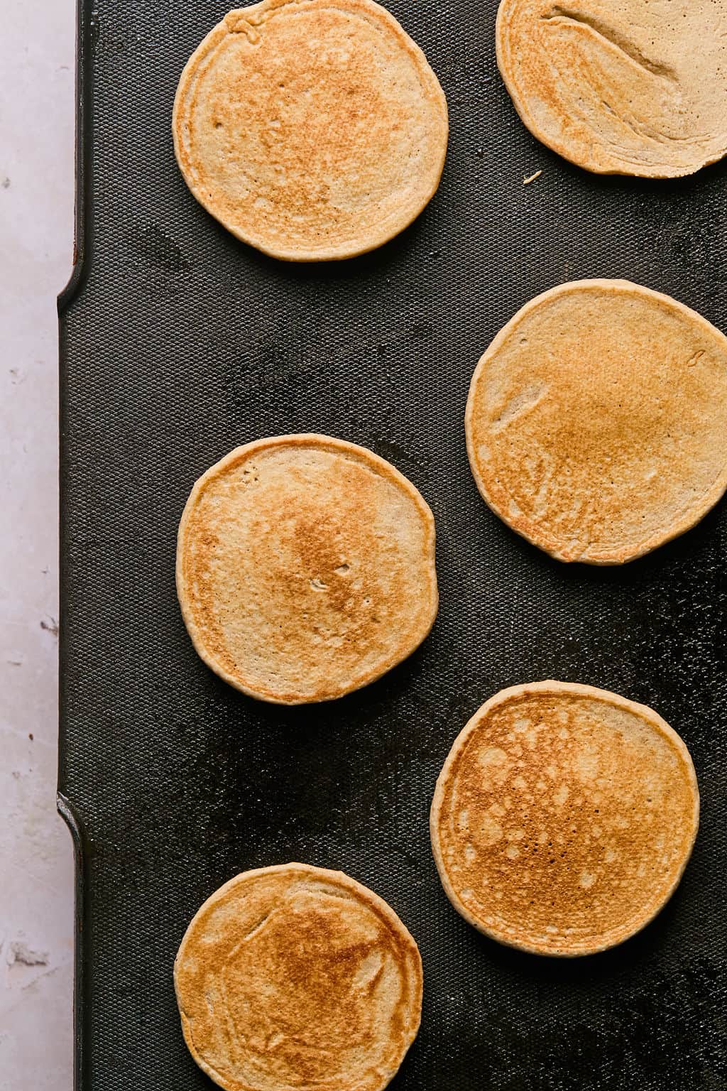 cooked banana oatmeal pancakes on a griddle.