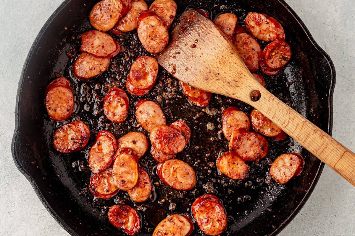sauteed andioulle sausage in a cast iron skillet