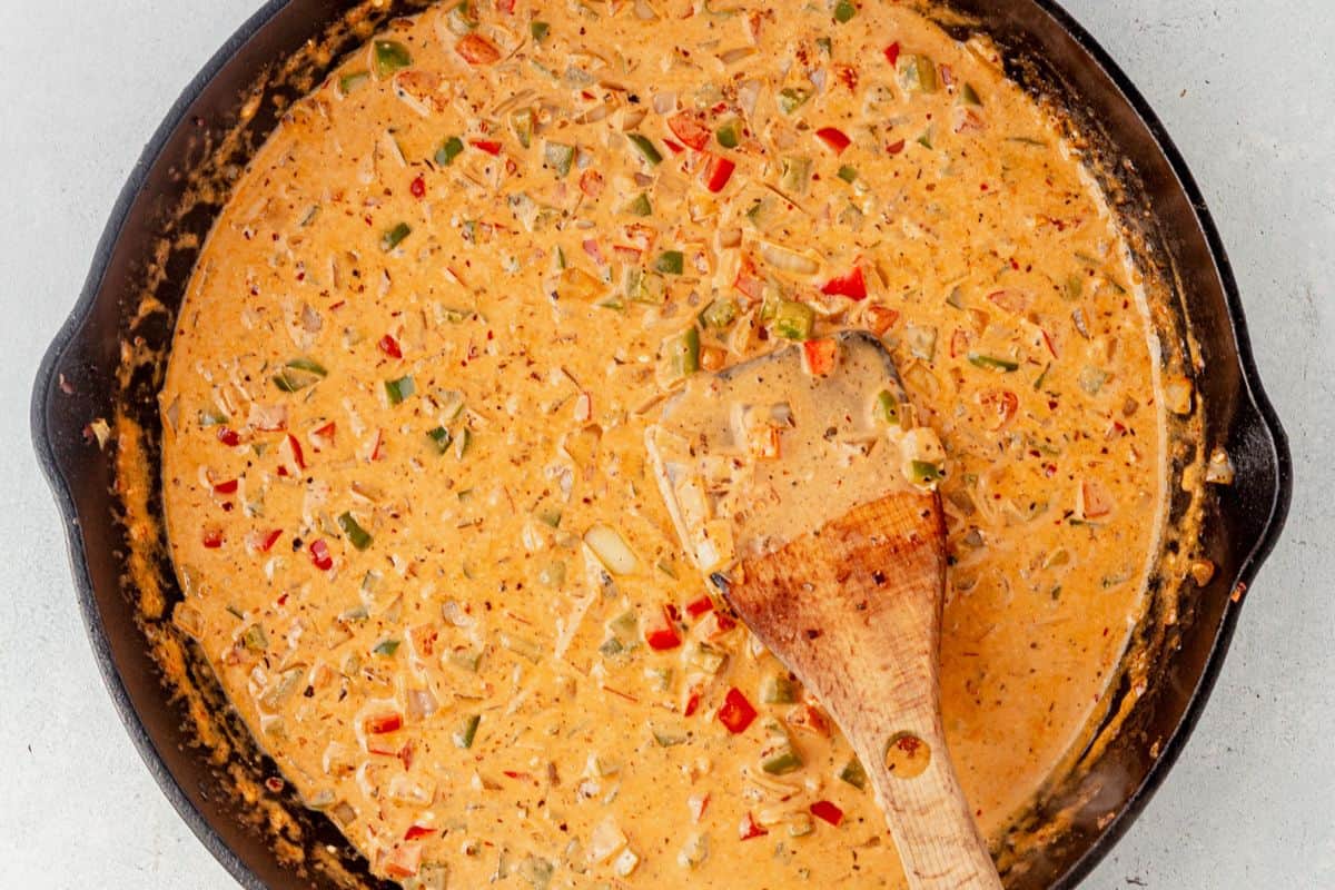 cajun cream sauce with peppers an onions in a skillet