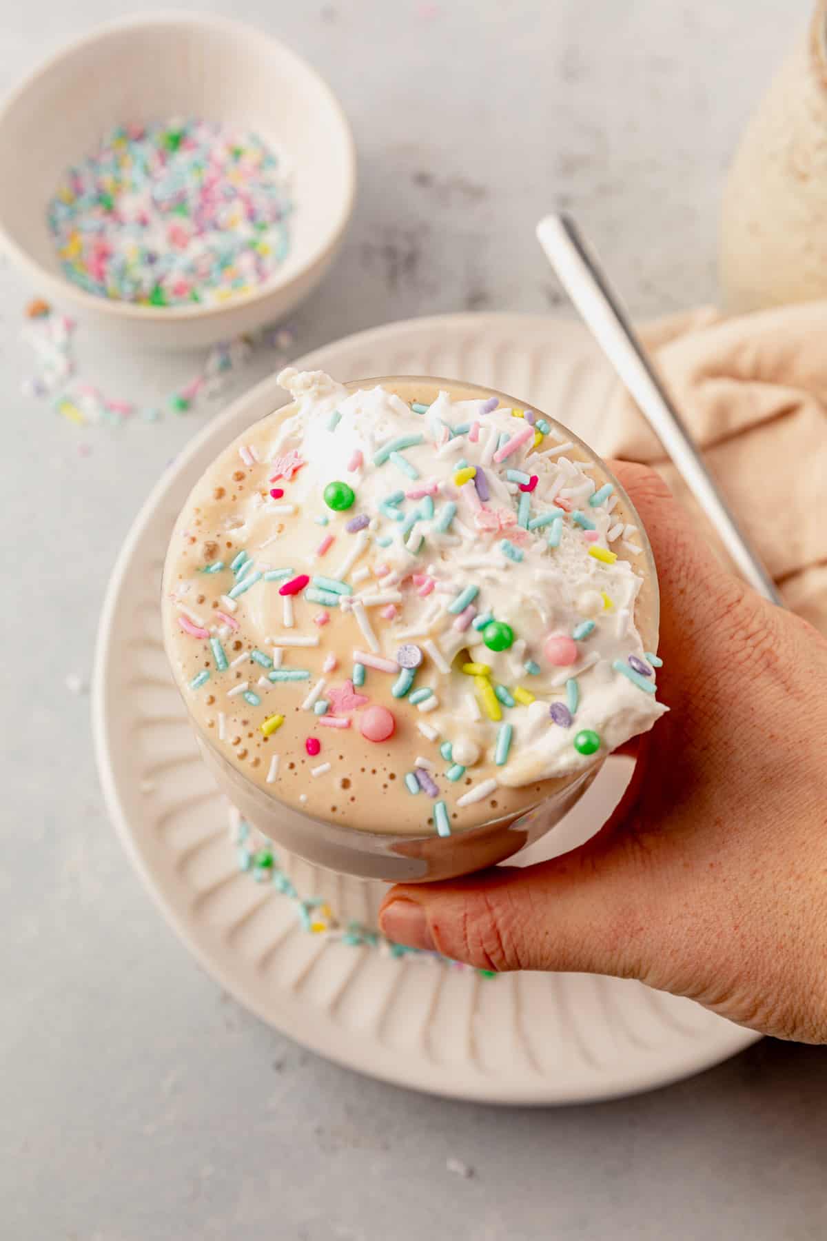 holding a cake batter protein shake