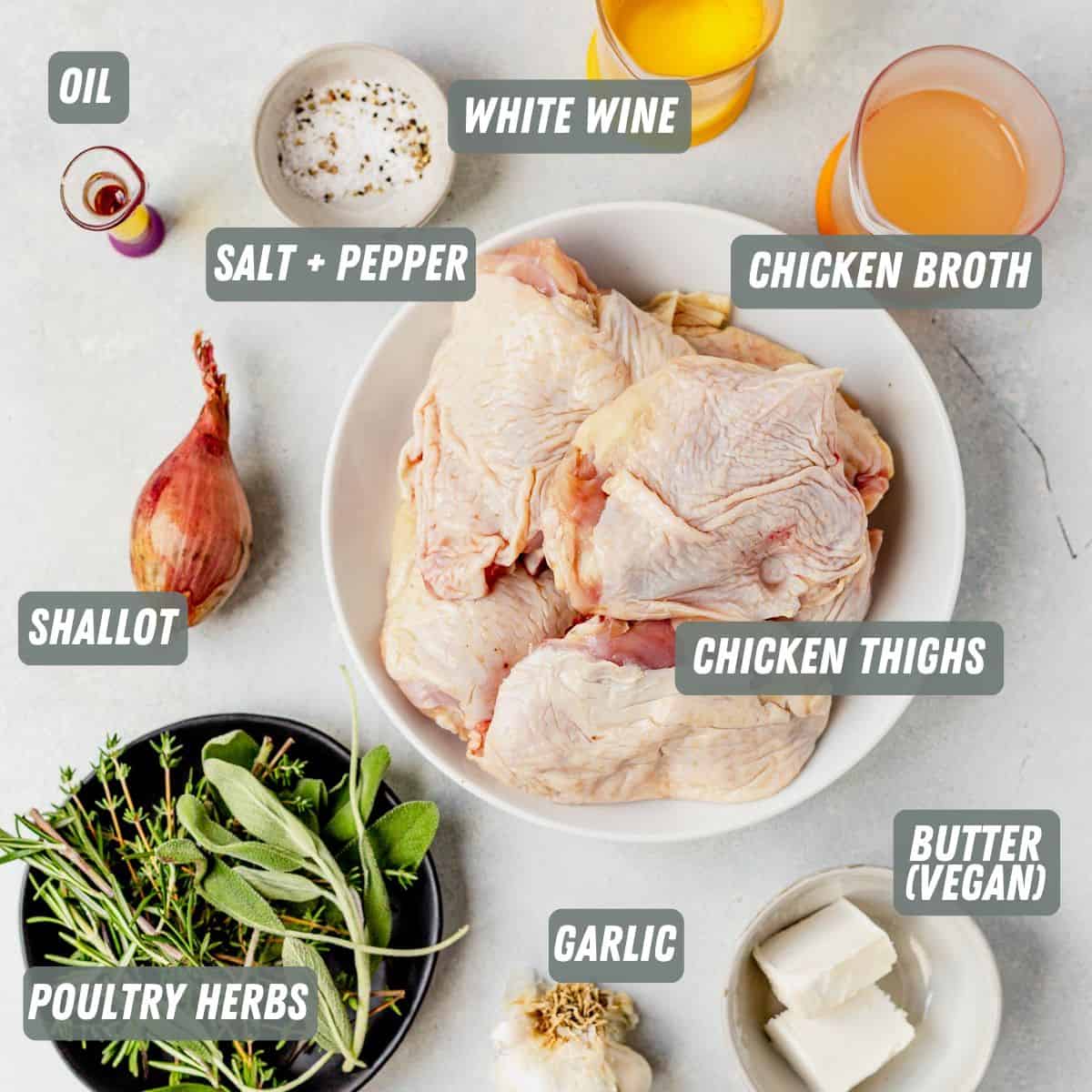 chicken thighs, herbs, shallot, butter, white wine, chicken broth and garlic on a table