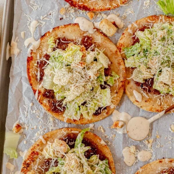 chicken caesar smash tacos on a sheet pan with parchment paper.