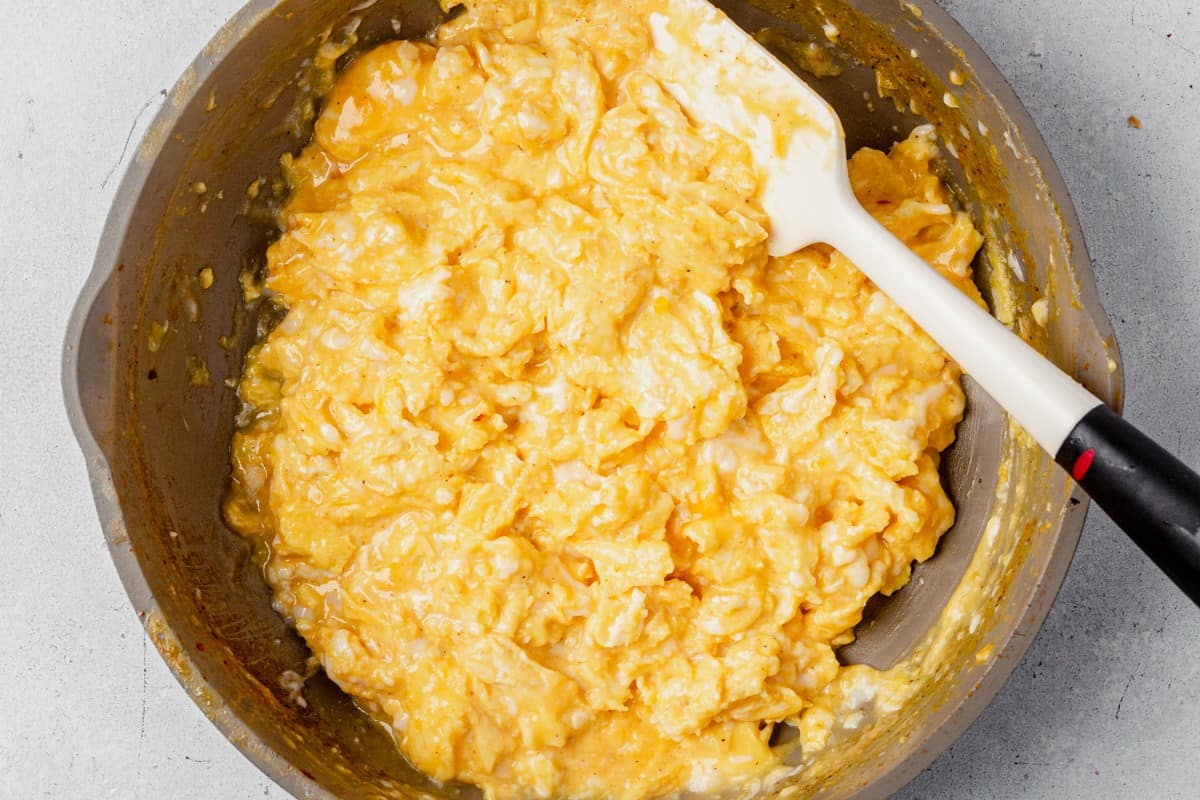 fluffy scrambled eggs with cheese in a skillet