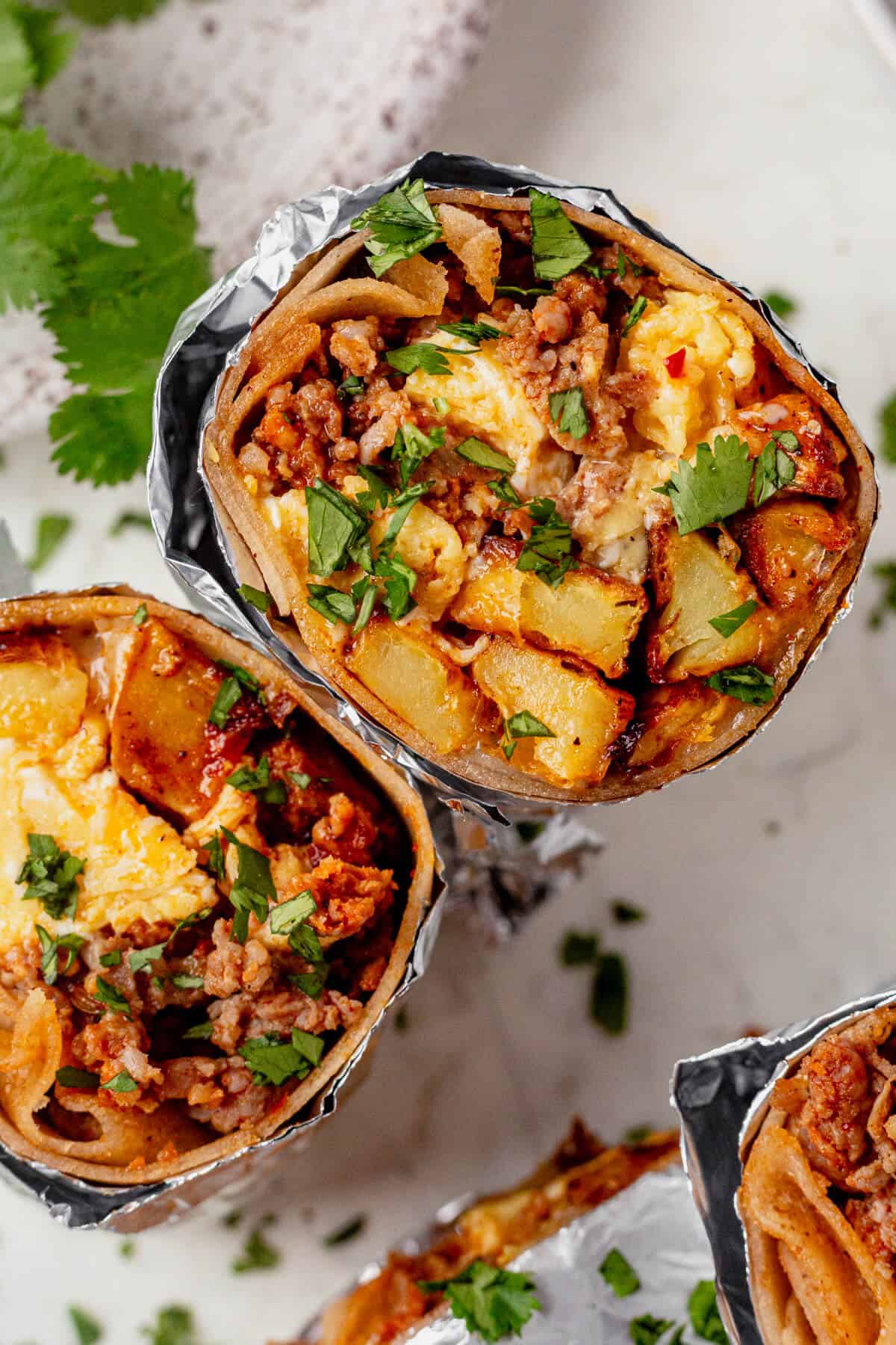 cheesy eggs, breakfast potatoes, and chorizo inside a burrito with foil