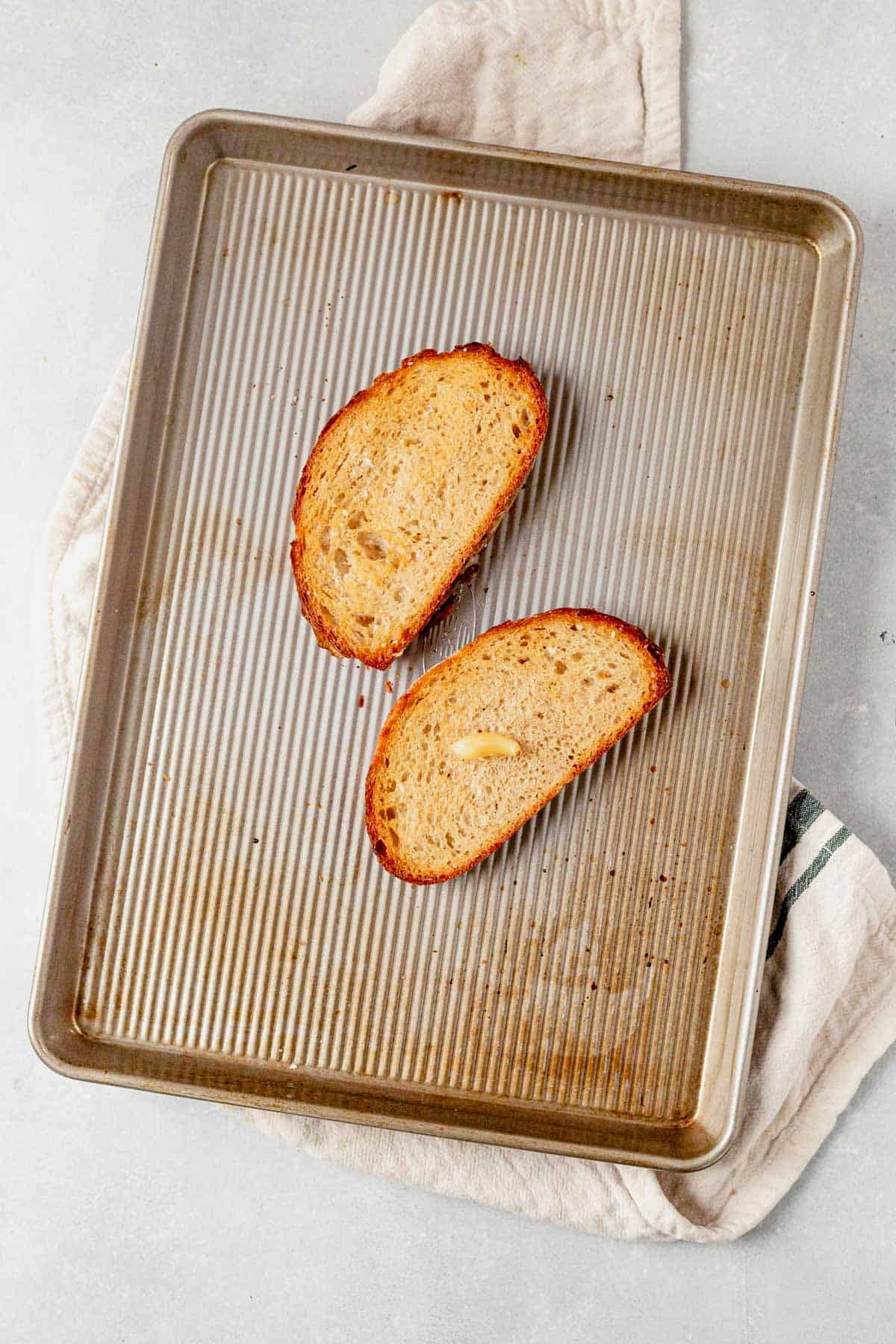 two pieces of toasted bread on a baking sheet
