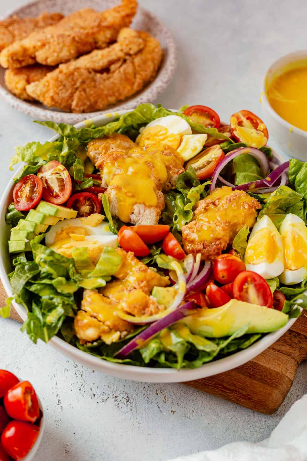 crispy chicken salad with eggs, avocado, toamto and chicken tenders