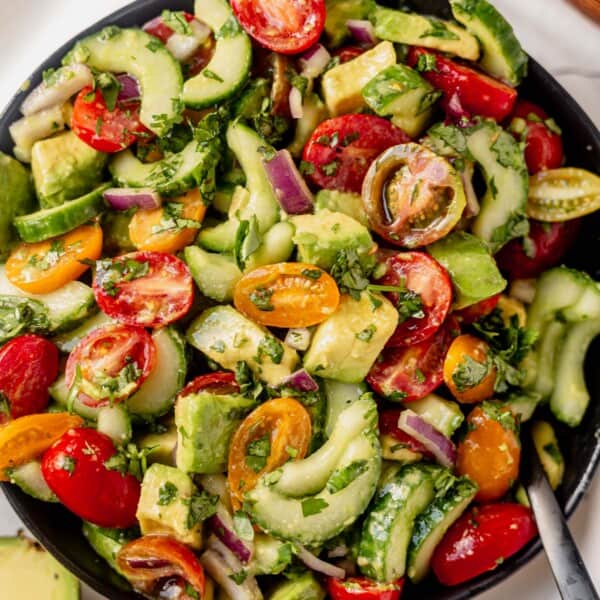a large bowl of cucumber tomato avocado salad