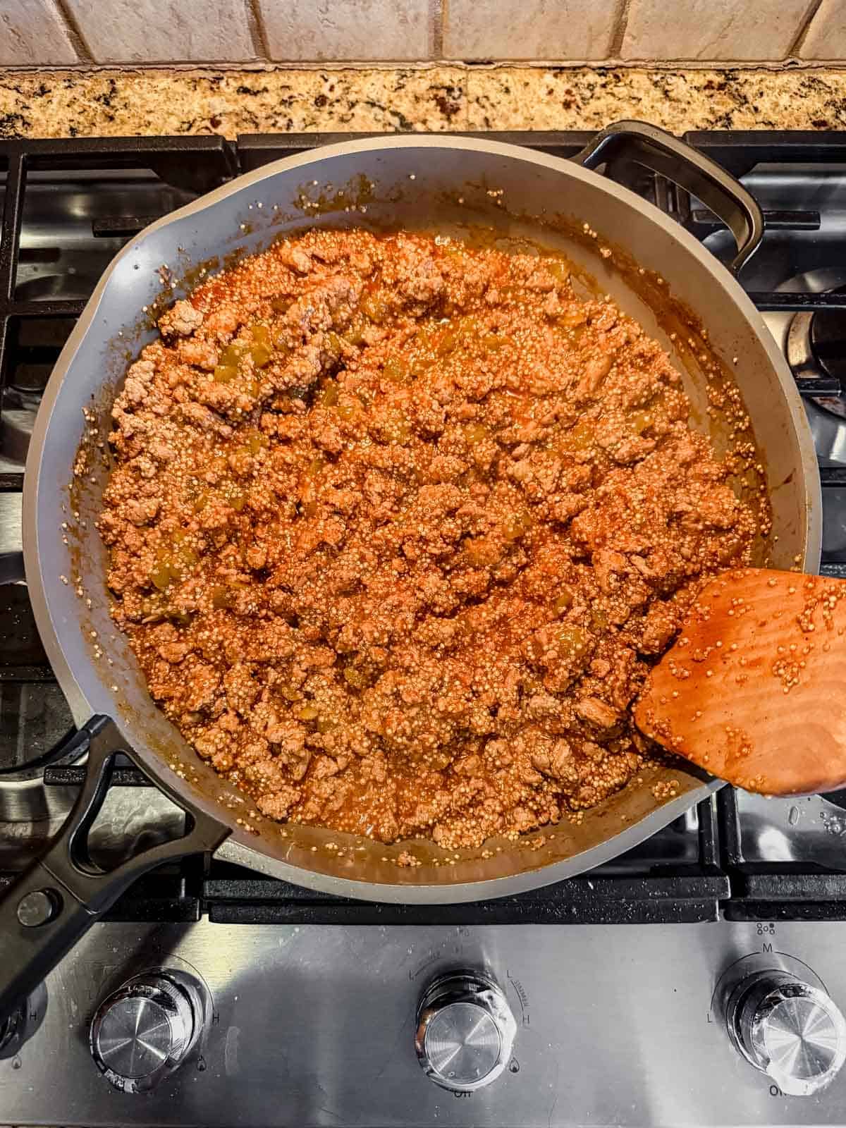 cooked ground turkey, quinoa, enchilada sauce, and chicken broth after simmering on the stove.