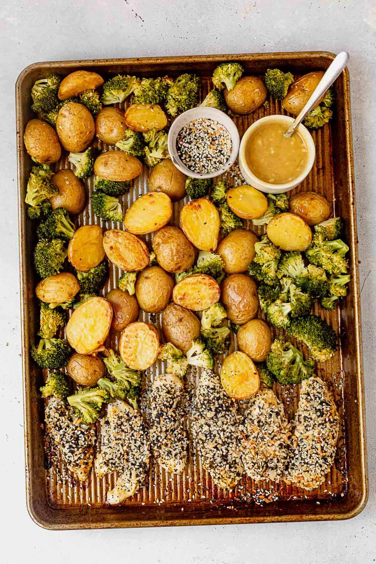 everything bagel chicken tenders on a baking pan with veggies
