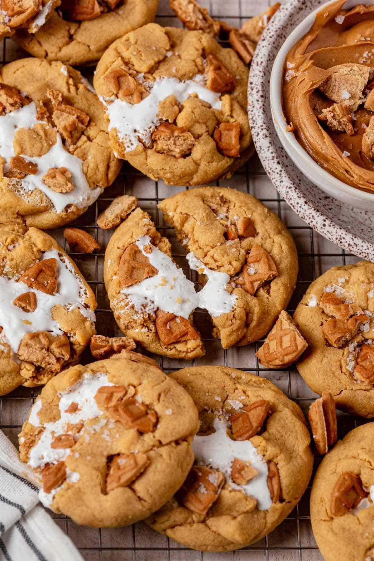 fluffernutter cookies laying out on a cooling rack with the middle cookies split in two with marshmallow fluff stretched between the two pieces.