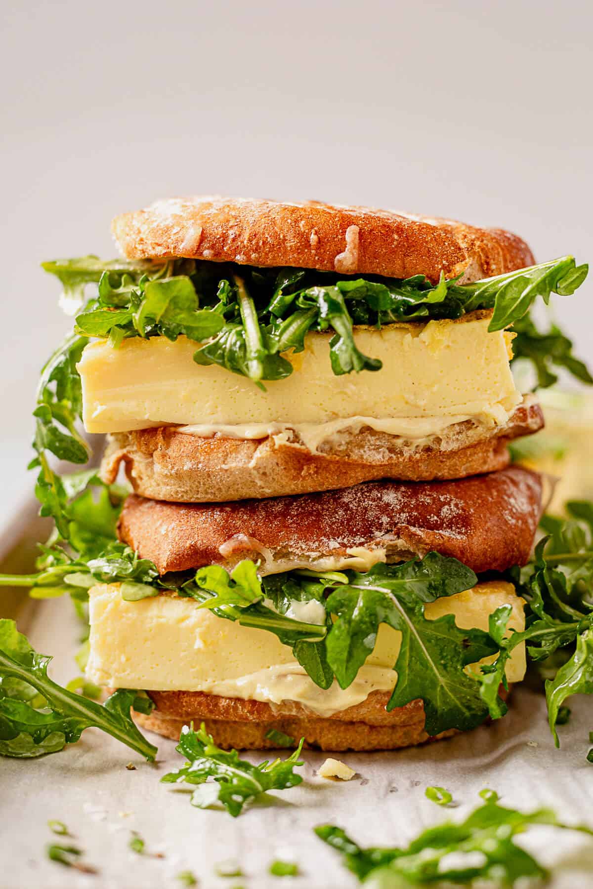 two fluffy egg sandwiches on buns stacked on top of each other