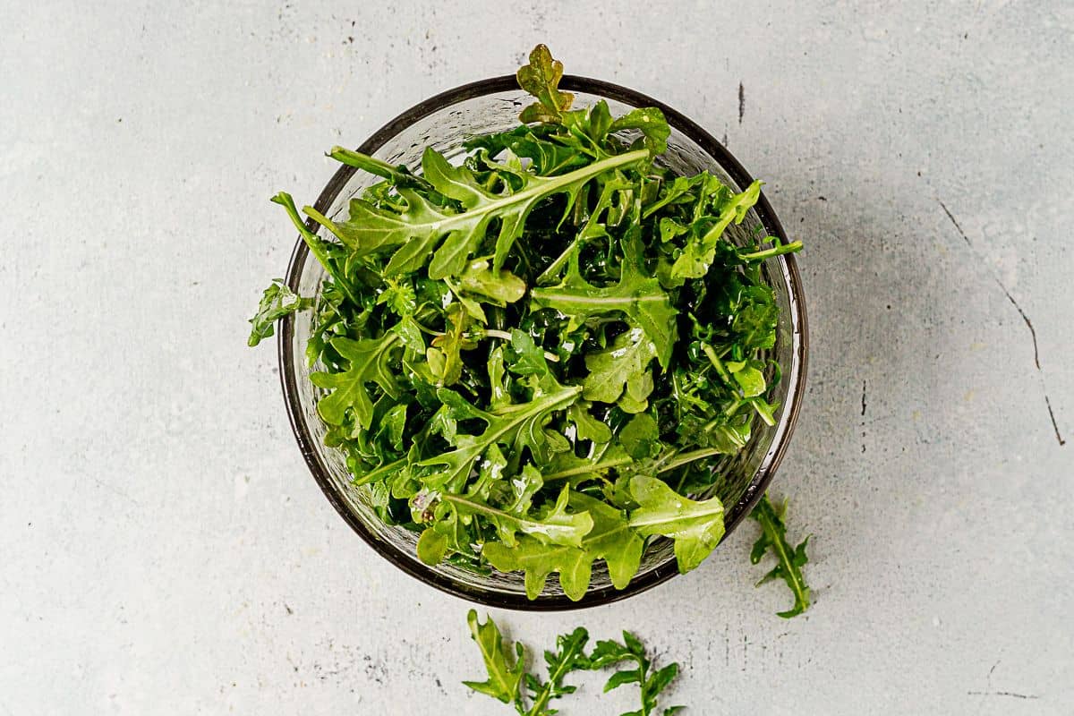 olive oil dressed arugula in a bowl