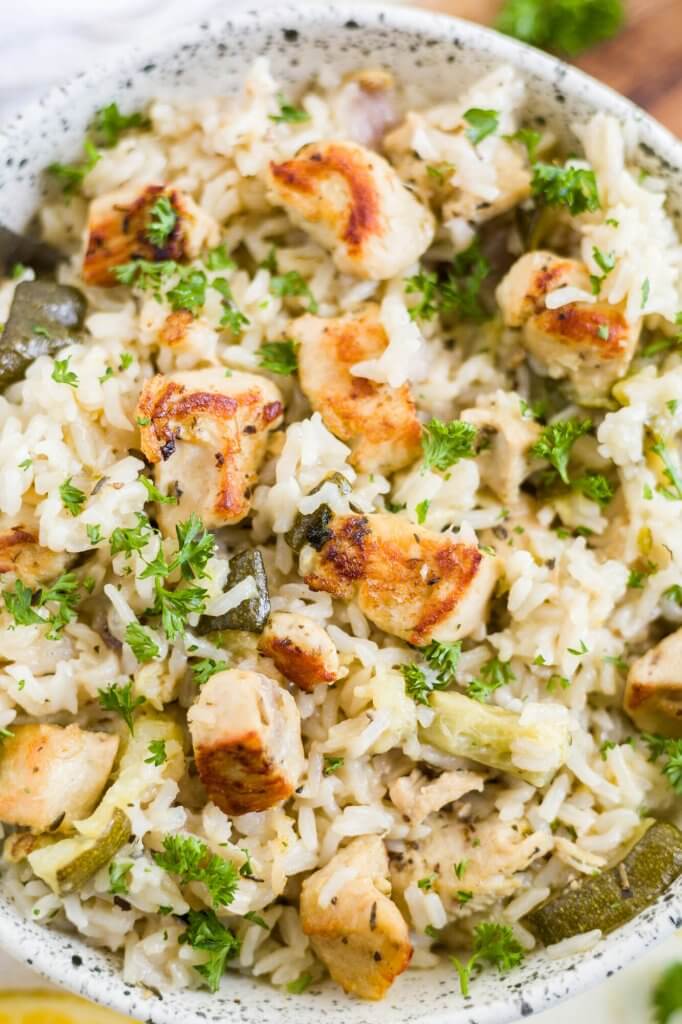 close up of marinated greek chicken with rice and fresh parsley