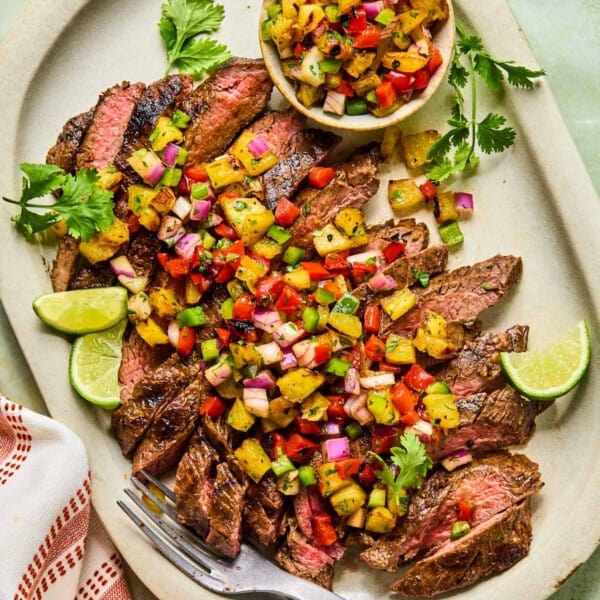 grilled flank steak and pineapple salsa served on a plate