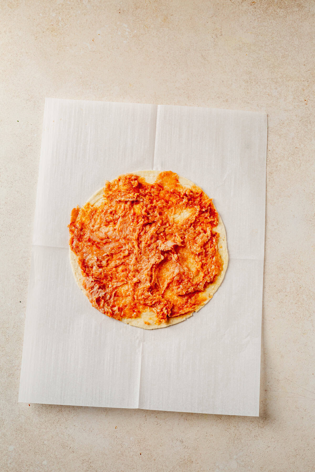 ground chicken mixture spread out onto a large tortilla.