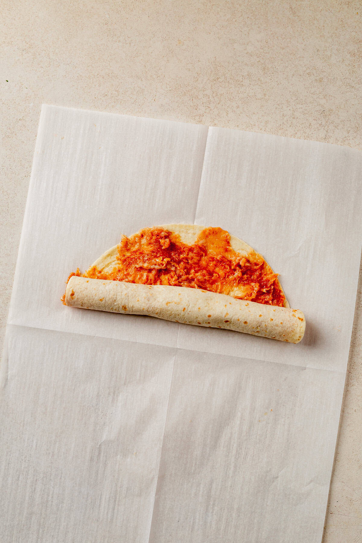 rolling a lazy kebab tortilla with ground chicken.