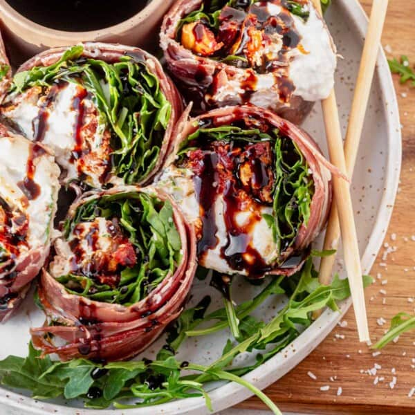 a plate of italian sushi drizzled with balsamic glaze.