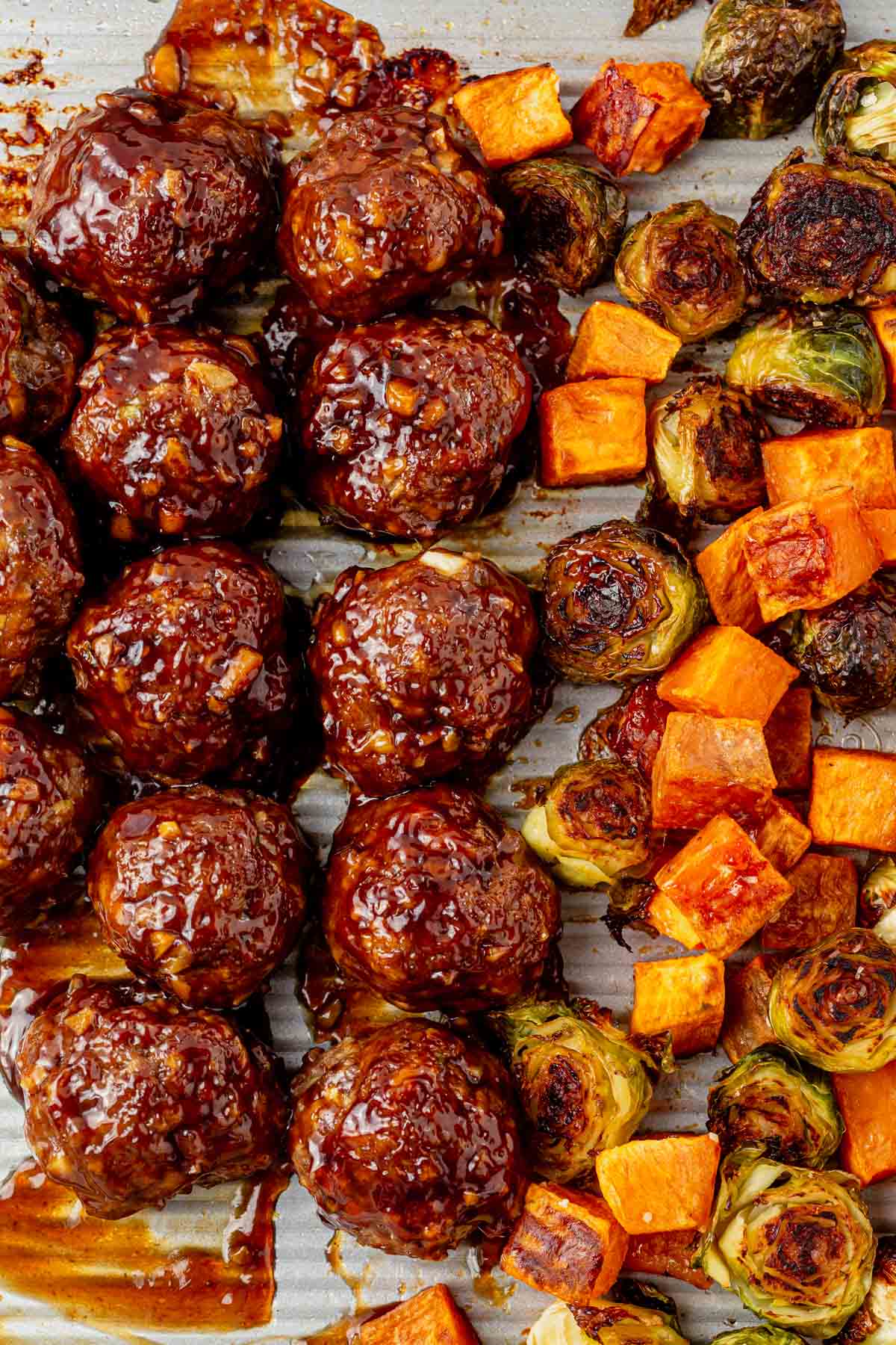 baked korean bbq meatballs on a sheet pan with roasted vegetables.