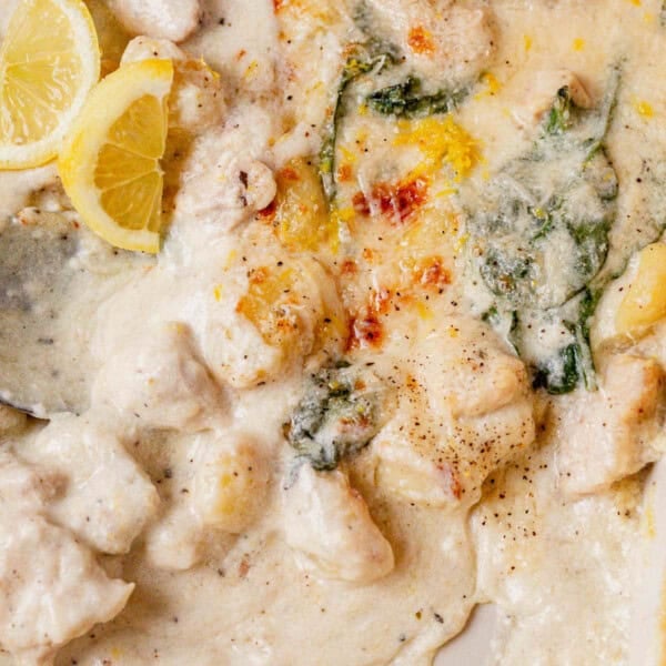 creamy lemon chicken gnocchi in a pan with a serving spoon.