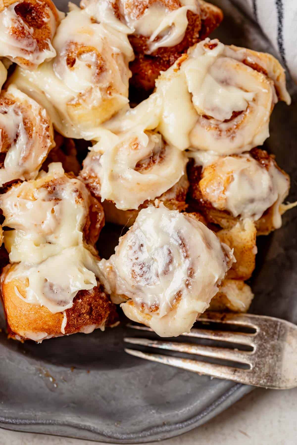 a plate of mini cinnamon rolls with a fork.