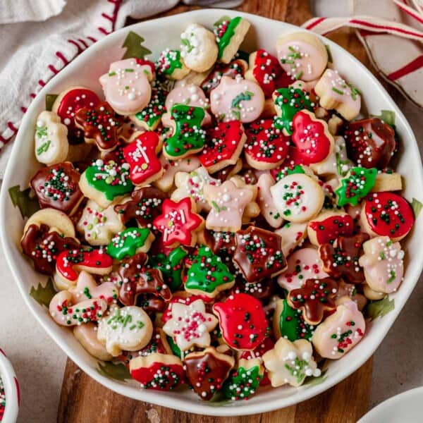 a bowl of decorated mini christmas cookies.