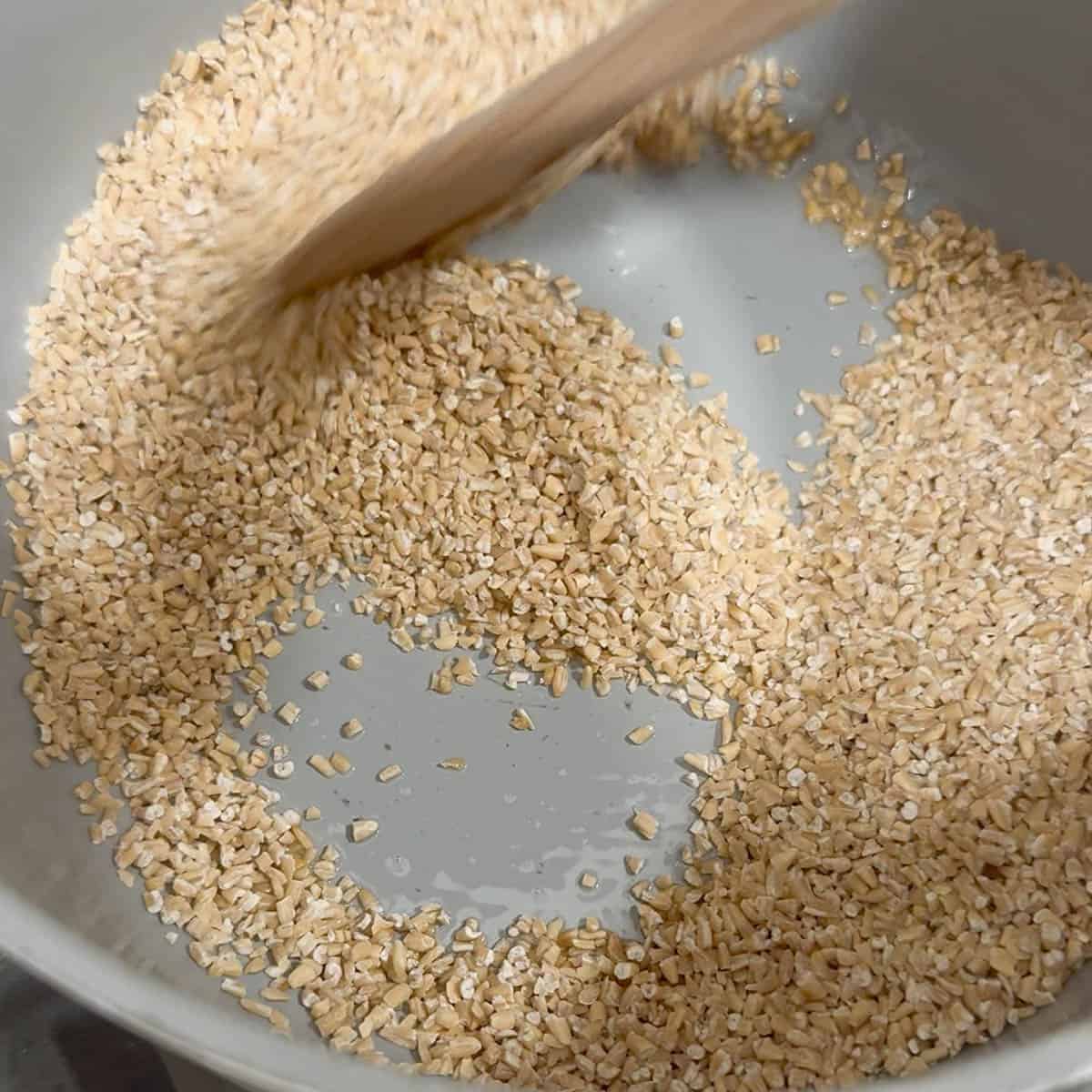 toasting steel cut oats and butter in a saucepan with a wooden spoon.