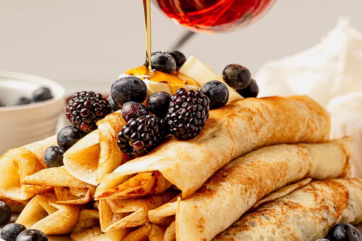 pouring syrup over pancake roll ups