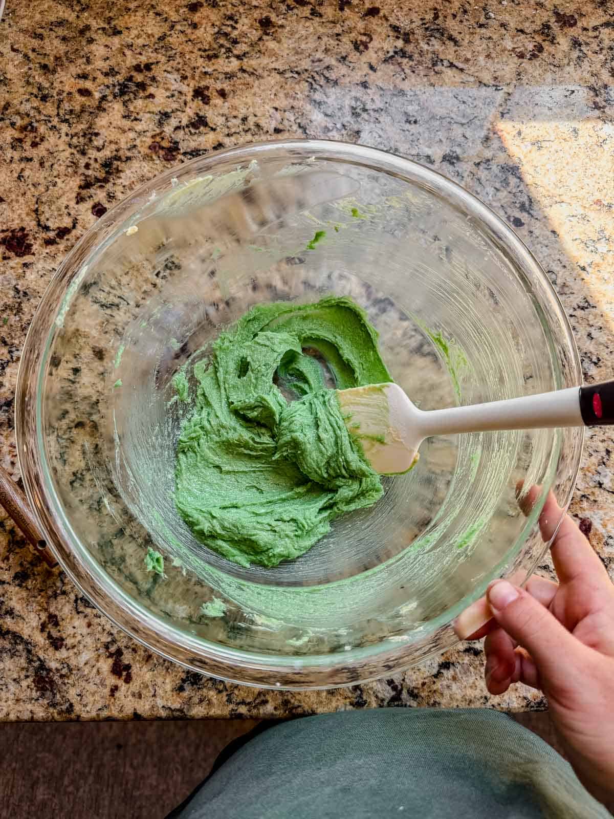 wet ingredients for pistachio linzer cookies mixed together in a glass bowl with a white rubber spatula