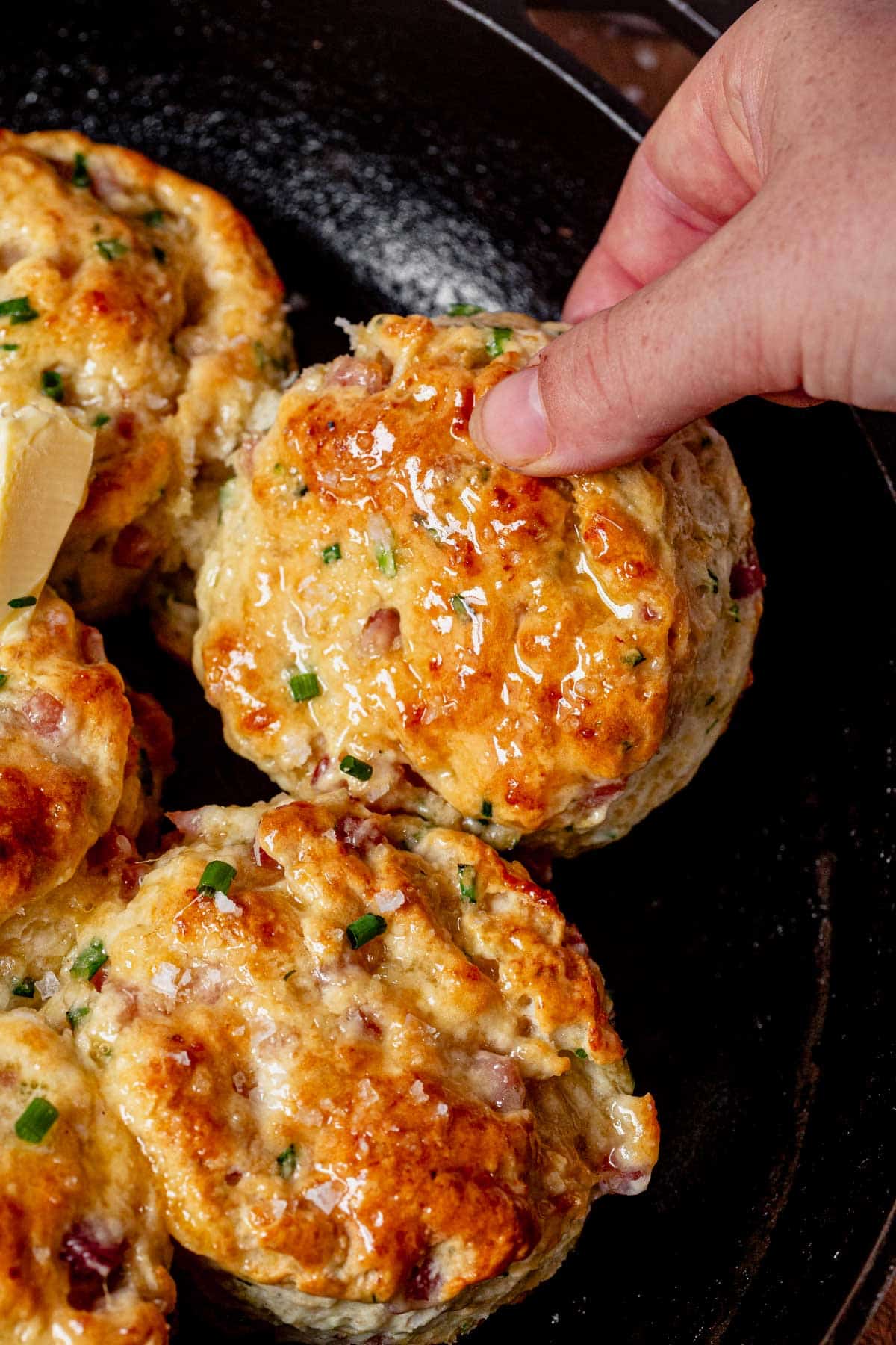 Picking up a freshly baked protein biscuit from a pan.