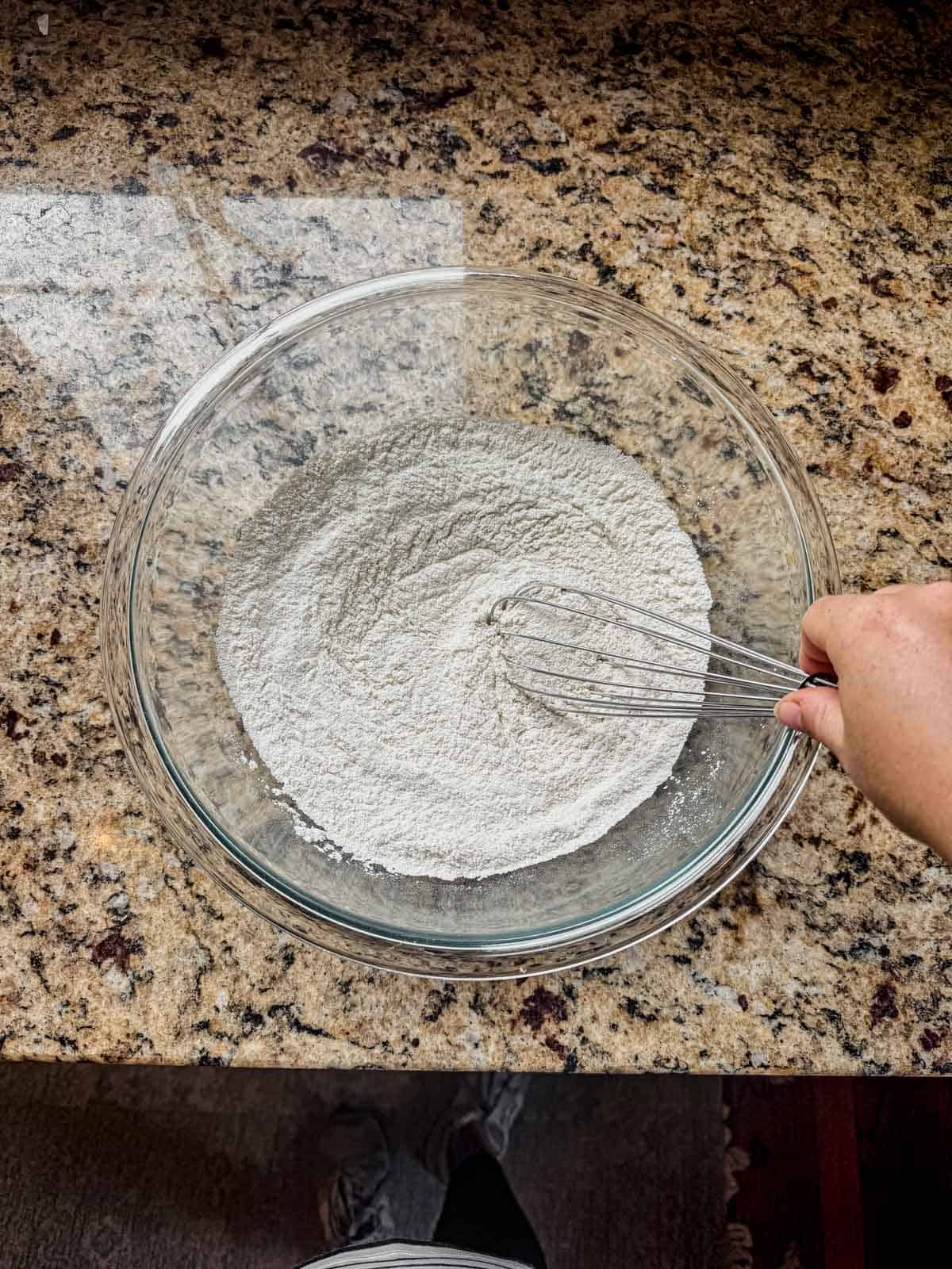 whisking flour, baking soda, baking powder, garlic powder, and salt in a bowl.
