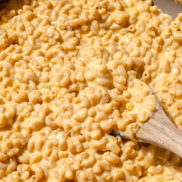 a wooden spoon in a batch of cottage cheese mac and cheese.