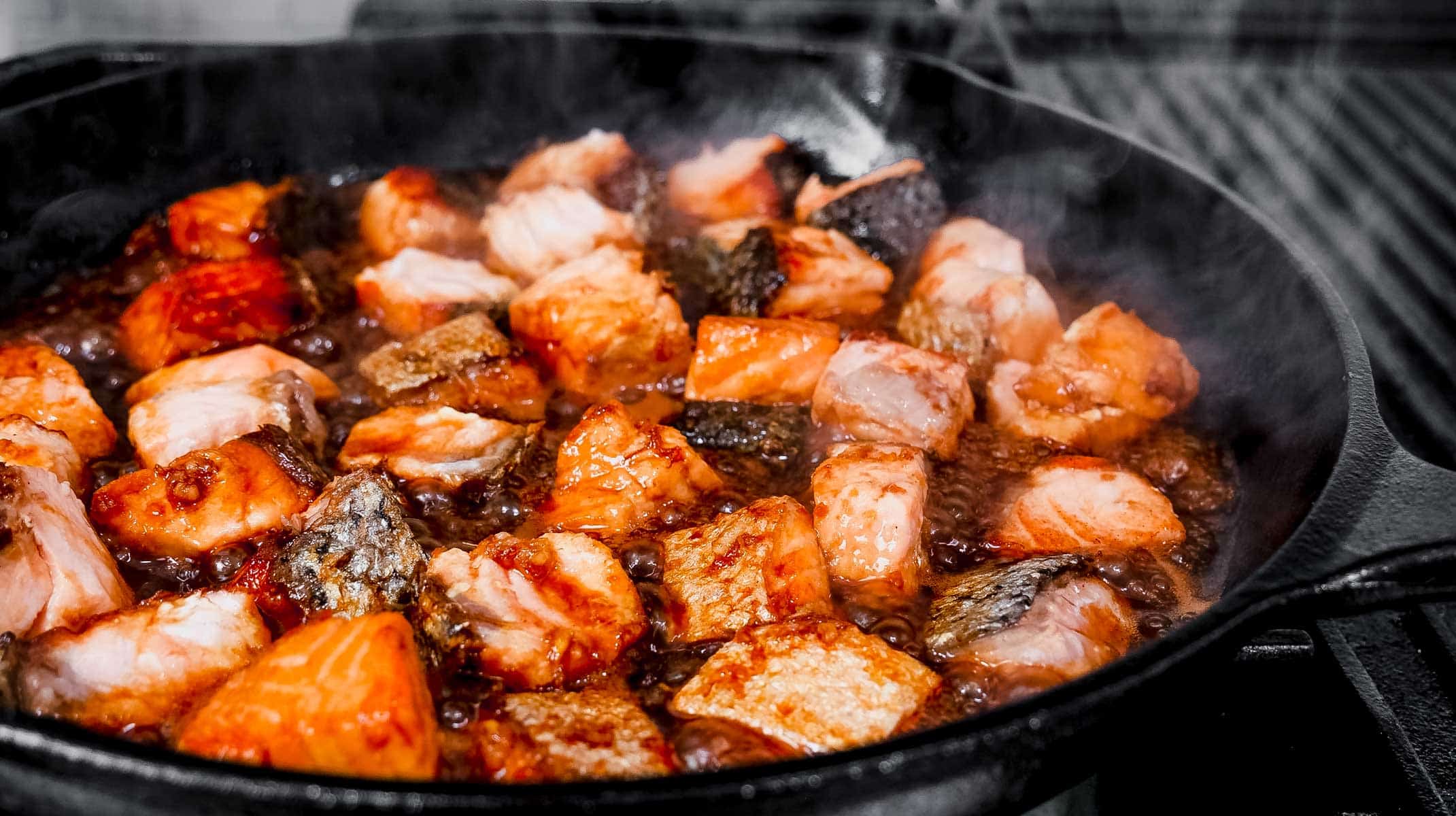 salmon chunks cooking in a skillet