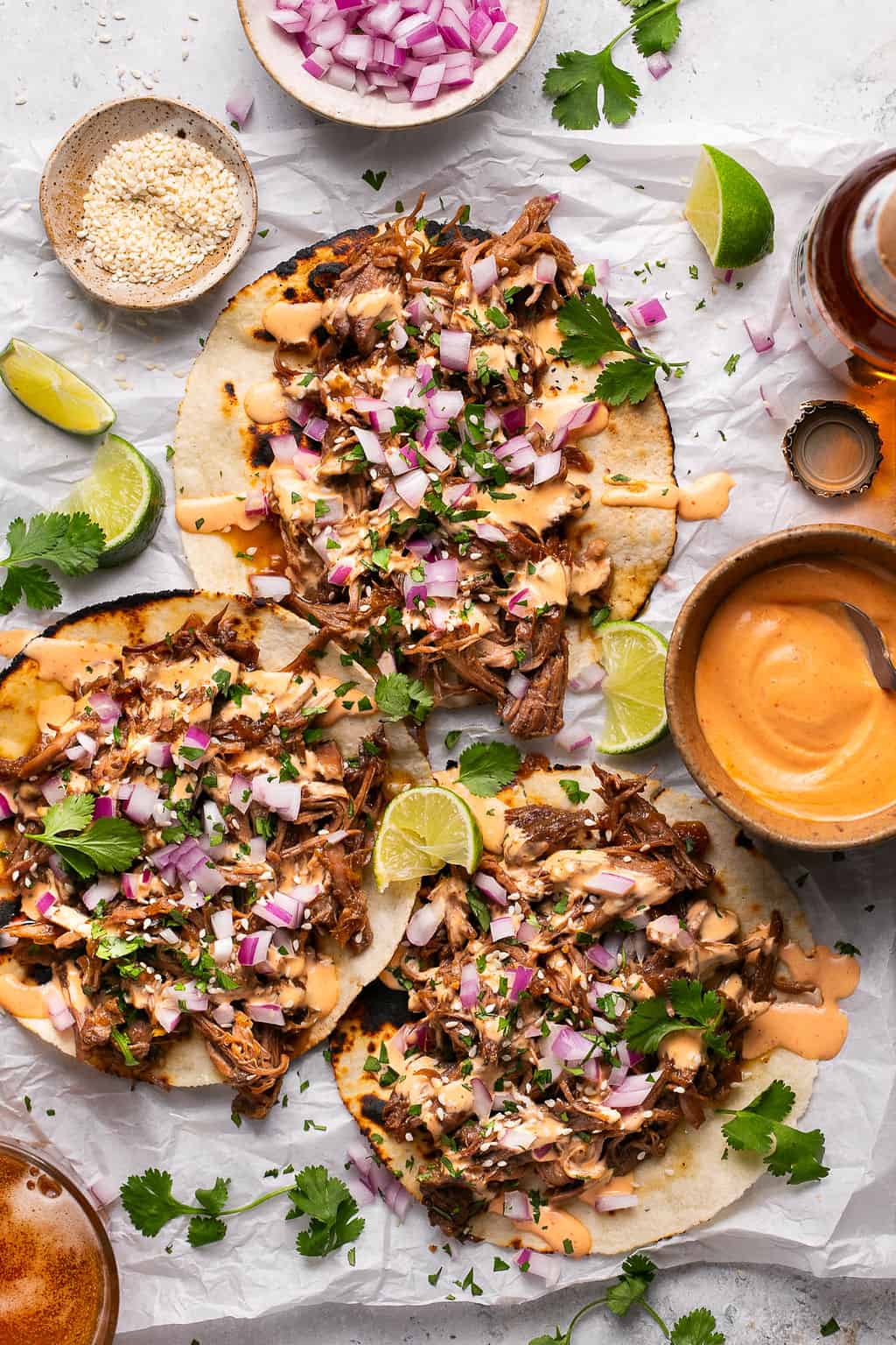 three slow cooker korean beef tacos with mayo, onion, and cilantro