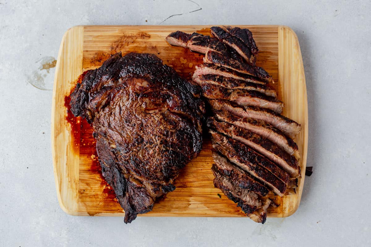 seared and sliced steak resting on a cutting board