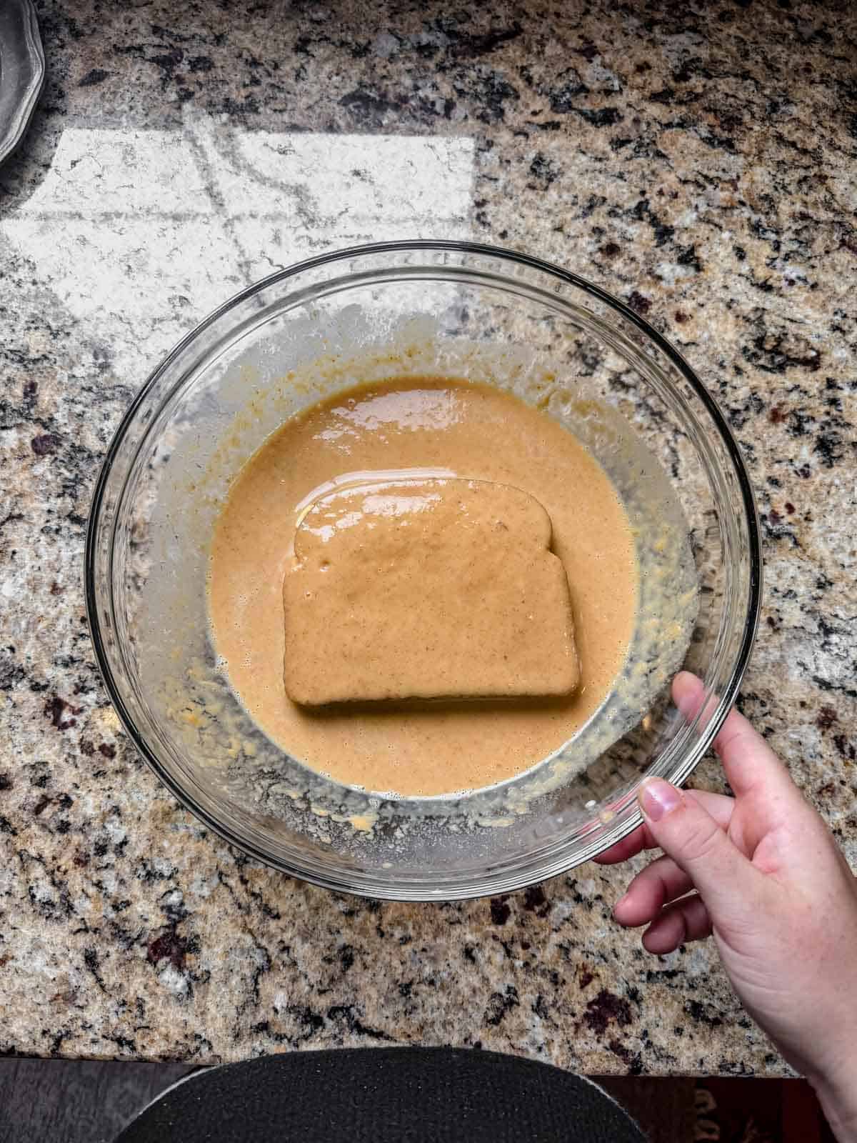 dipping stuffed french toast into pumpkin custard.