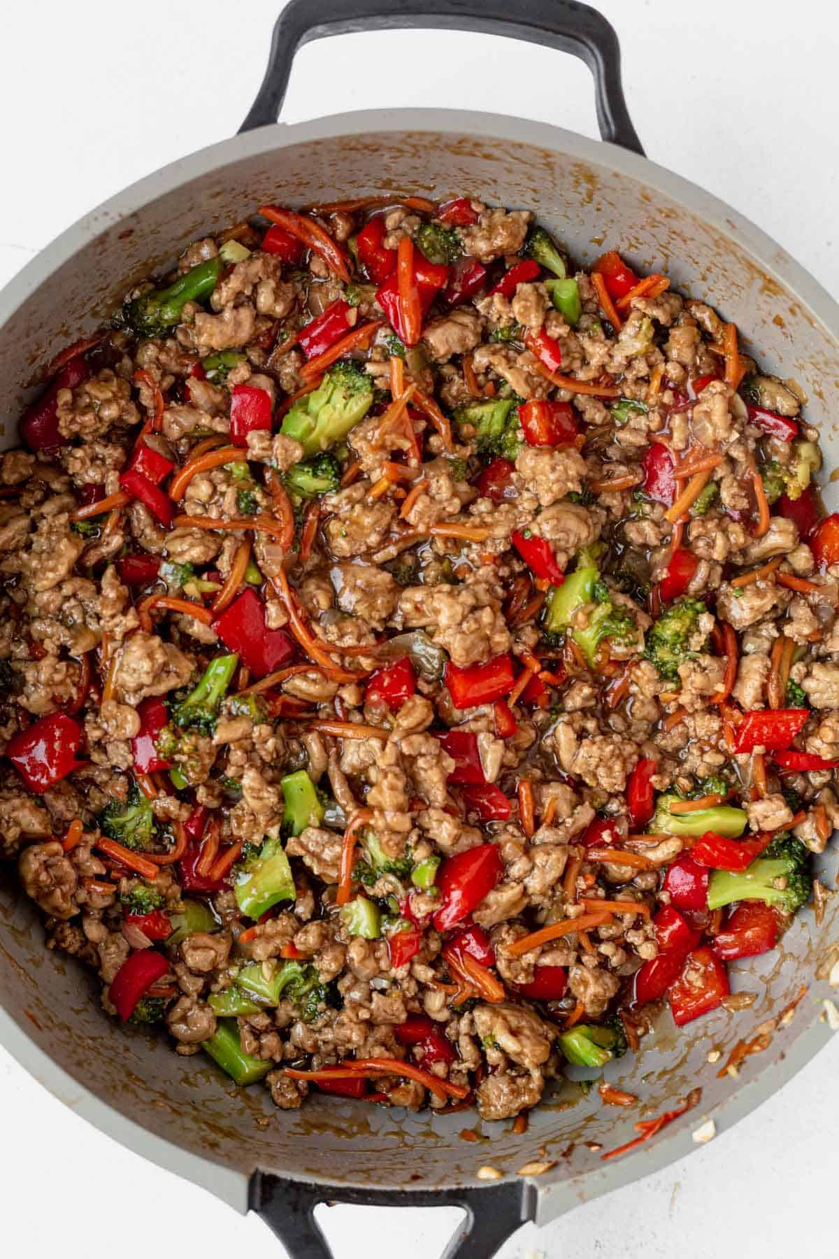ground turkey and vegetables in a pan with teriyaki sauce