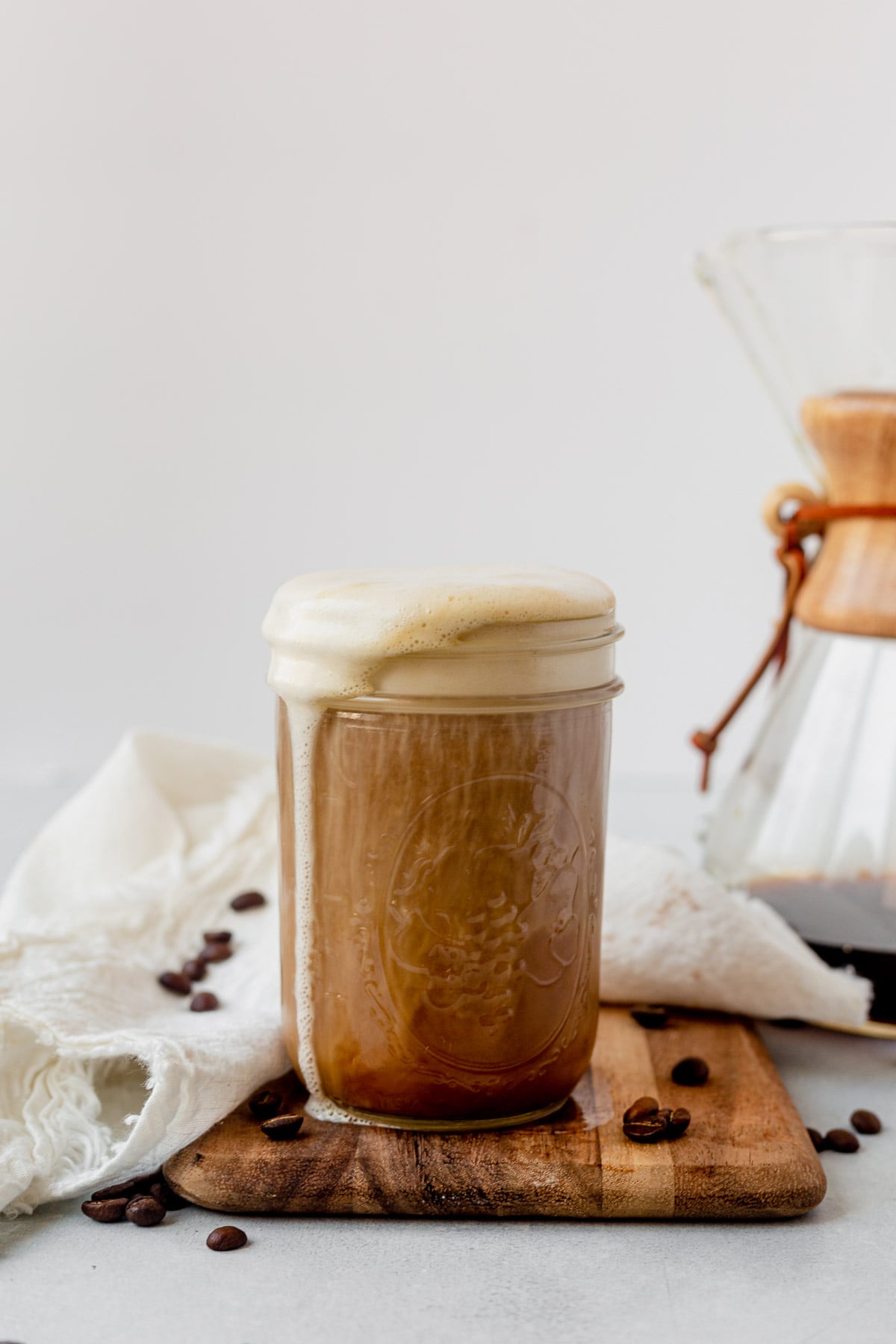 vanilla sweet cream cold foam pouring over the edge of a mason jar full of cold brew coffee