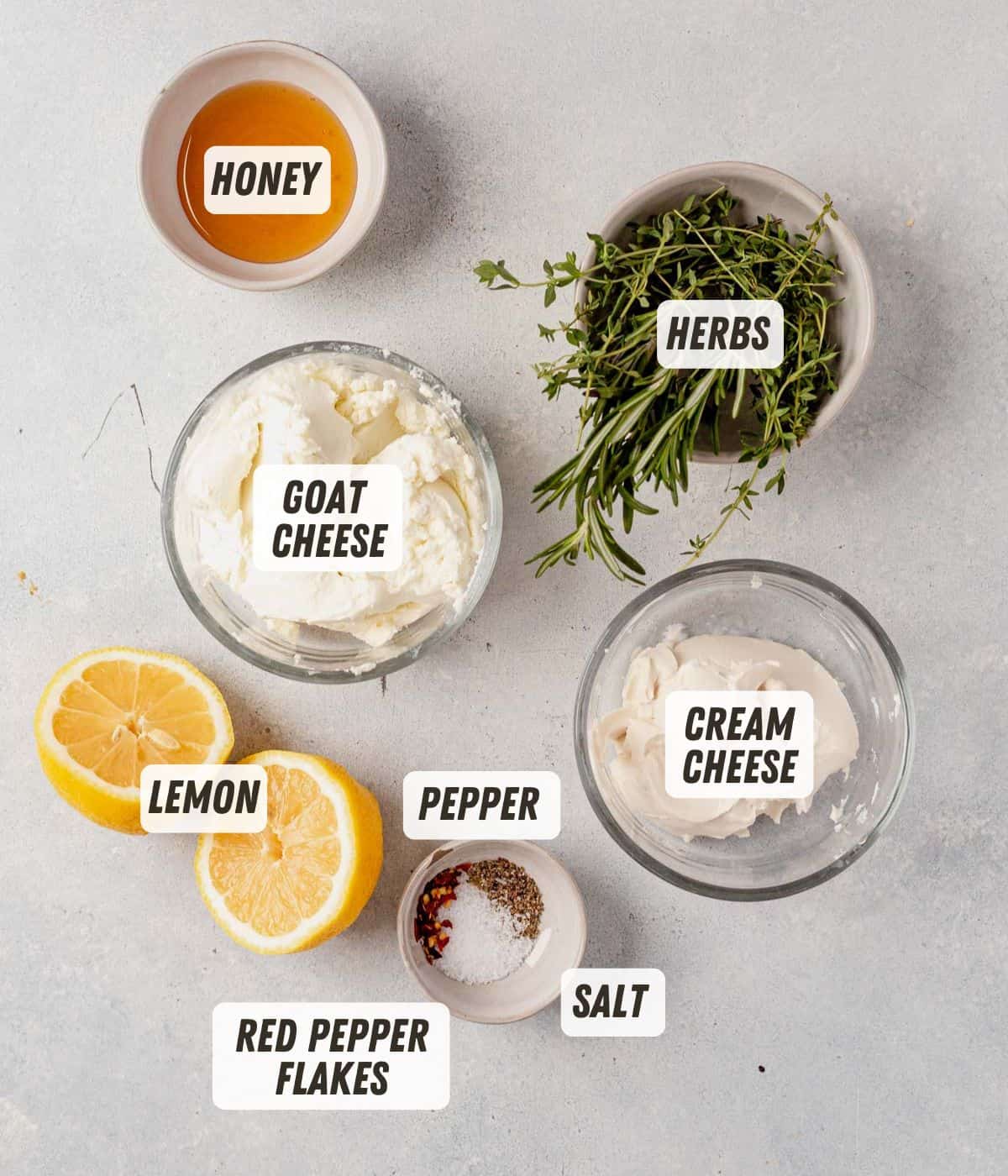 honey, goat cheese, cream cheese and herbs on a countertop