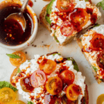 pieces of cottage cheese toast topped with diced grape tomatoes and hot honey